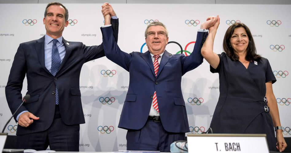 Thomas Bach, presidente del COI, levanta los brazos de Eric Garcetti, alcalde de Los Ángeles, y de Anne Hidalgo, alcaldesa de París